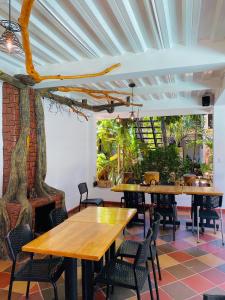 a restaurant with wooden tables and chairs in a room at Hotel Colonial Sol y Luna in Paz de Ariporo