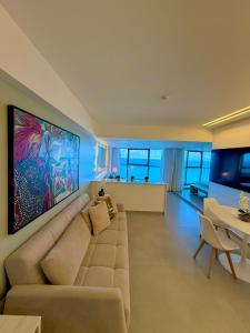 a living room with a couch and a large painting on the wall at Refuge Beira Mar - Boa Viagem in Recife