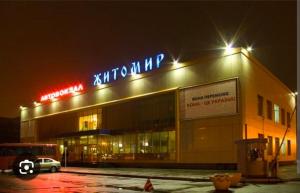 a building with a sign on top of it at night at Апартаменти Aura Bliss in Zhytomyr