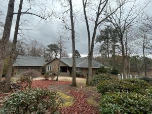 a house in the woods with trees at Spacious Lakefront in Fayetteville