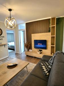 a living room with a couch and a tv at Nessii Apartment in Prishtinë