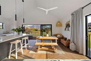 a kitchen and living room with a table and chairs at Luxury Mountain View Retreat in Frankton