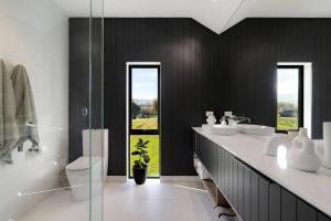 a bathroom with two sinks and a toilet and a shower at Luxury Mountain View Retreat in Frankton