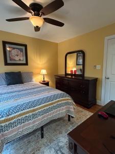 a bedroom with a bed with a ceiling fan and a dresser at Spacious Lakefront in Fayetteville