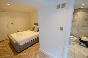a bedroom with a bed and a bathroom with a toilet at Rye Hideaway with Hot Tub - Rye in Rye