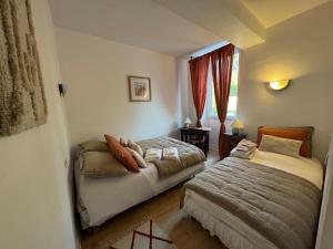 a bedroom with two beds and a window at Ancien hôtel du Thaurion in Saint-Hilaire-le-Château