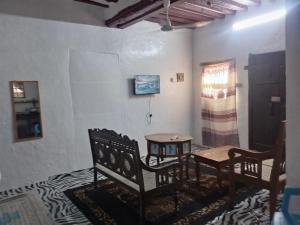 a room with two chairs and a table and a window at Beiytul Noor Apartment in Lamu