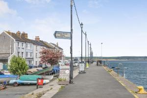 a dock with a street sign next to the water at 3 Bed in Appledore oc-phoe in Appledore