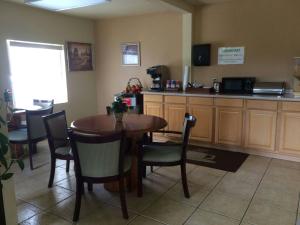 a dining room with a table and chairs and a kitchen at Executive Inn Schulenburg in Schulenburg