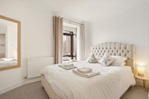 a bedroom with a large white bed with a large mirror at 2 Bed in Swanage oc-wy547 in Swanage