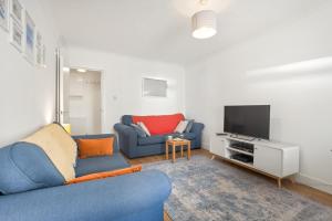a living room with a blue couch and a tv at 2 Bed in Swanage oc-wy547 in Swanage