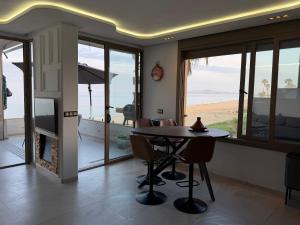 a dining room with a table and a view of the beach at Alamine plage in Fnidek