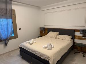 a bedroom with a bed with towels on it at Alamine plage in Fnidek
