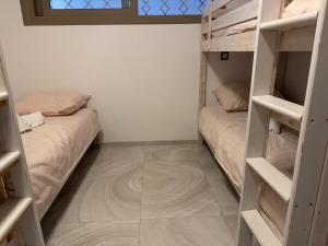 a room with two bunk beds and a tiled floor at Alamine plage in Fnidek