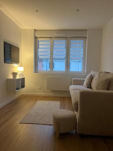 a living room with a couch and a window at Le Studio Chic in Le Portel