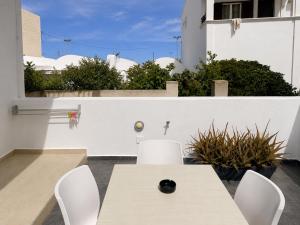 a patio with a table and chairs and a fence at Selena Villa in Kamari