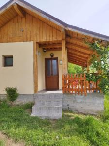 a house with a wooden door and a porch at Casa Maria in Ciocaşu