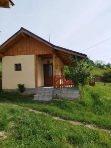 a small house in the middle of a field at Casa Maria in Ciocaşu