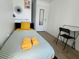 a bedroom with a bed with two yellow towels at Chambre salle d'eau privée in Brest