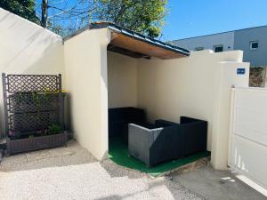 a white building with a gate and a black bench at Chambre salle d'eau privée in Brest