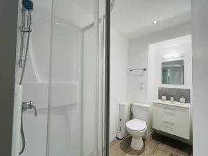 a white bathroom with a toilet and a shower at Chambre salle d'eau privée in Brest +9 photos