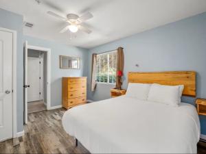 a bedroom with a white bed and a ceiling fan at Meadowlark Retreat in Ahwahnee