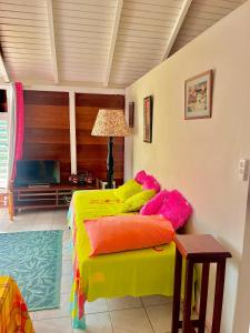 a bedroom with a bed with colorful pillows at appartement T2 cosy avec piscine in Baie-Mahault