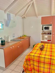 a kitchen with a yellow and red checkered table cloth at appartement T2 cosy avec piscine in Baie-Mahault