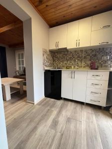 a kitchen with white cabinets and a wooden floor at Deluxe Family Stay Near The Beach in Kvariati