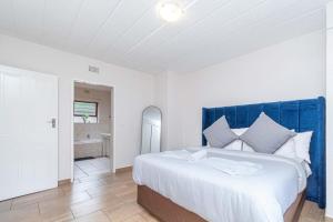 a bedroom with a large bed with a blue headboard at 3 bed ground in sandton in Johannesburg +15 photos