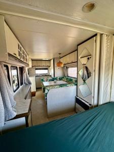 a bedroom in an rv with a bed and a table at Przyczepa Wendy in Jastarnia