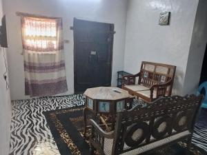 a living room with two chairs and a table at Beiytul Noor Apartment in Lamu