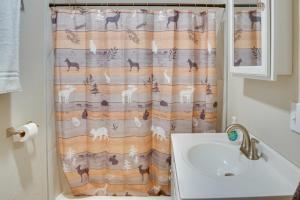 a bathroom with a shower curtain with a sink at Kenai River Base! Spacious 2-Unit Cabin Compound in Soldotna +21 photos