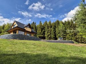 a house on top of a grassy hill at Dom z Widokiem na Tatry- Luxury Chalet in Klikuszowa