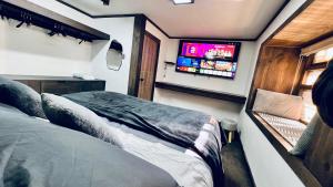 a bedroom with two beds and a tv on the wall at House 78 in Coquimbo +8 photos