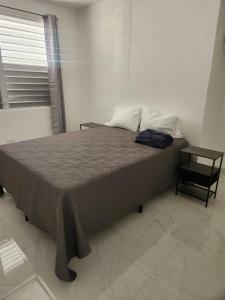 a bed in a room with a window and a table at 2BR Apartment, Blue Ocean Suites, Manati in Manati