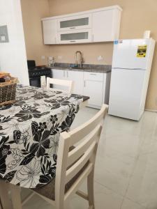 a kitchen with a table and a white refrigerator at 2BR Apartment, Blue Ocean Suites, Manati in Manati