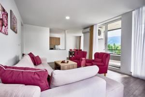 a living room with two white couches and purple chairs at Regency Aparthotel Sarajevo in Sarajevo