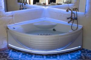 a white bath tub in a bathroom with a mirror at QUART0 GREC0 Suite 17 in Altamura +2 photos