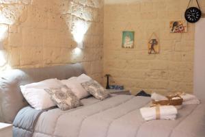 a bedroom with a large white bed with pillows at QUART0 GREC0 Suite 17 in Altamura