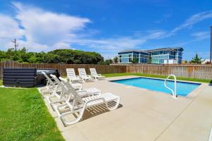a group of lounge chairs next to a swimming pool at 4058 - Beach Haven in Kitty Hawk