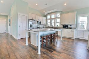 a large kitchen with white cabinets and a large island at 4058 - Beach Haven in Kitty Hawk +69 photos