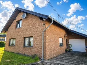 a brick house with a garage at Käthe's Gästezimmer in Reimerath +4 photos