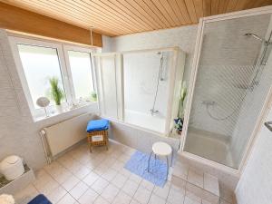 a large bathroom with a shower and a tub at Käthe's Gästezimmer in Reimerath