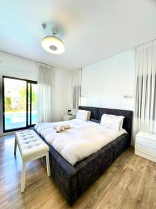 a bedroom with a large bed with a teddy bear on it at Villa Casa Blanca in Kefar H̱ananya +40 photos