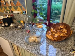 a counter top with a bowl of bread and a basket of pastries at Le Mirail in Brugnac