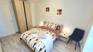 a bedroom with a bed and a blue chair at L'appartement de Maya in Saint-Priest