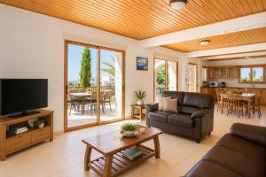a living room with a couch and a television at Villa Chrisandria in Argaka