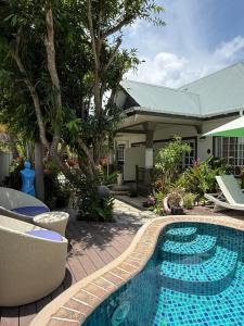 a swimming pool in front of a house at Maison Charme De L'ile in La Digue