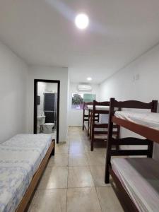 a room with two beds and a bathroom with a mirror at Cantinho do Mar in Bertioga
